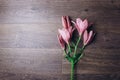 Bouquet of pink lily flowers in the rays of light on a wooden rustic table. fresh buds of a flowering plant close-up, copy space, Royalty Free Stock Photo