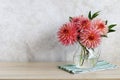 A bouquet of pink needle dahlias in a glass jug