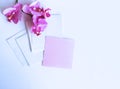 A bouquet with pink orchid flowers and a notebook for notes on a white background. Royalty Free Stock Photo