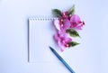 A bouquet with pink orchid flowers and a notebook for notes on a white background. Royalty Free Stock Photo