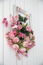 Bouquet of pink orchids, roses and peons in a large frame hanging on the wall Royalty Free Stock Photo