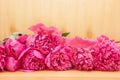 Bouquet of pink peony flowers on wooden background, beautiful card with blossom and copy space