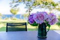 Bouquet of pink and purple flowers in a vase on the table in the garden Royalty Free Stock Photo