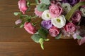 Bouquet of pink roses in basket on wooden background closeup. Roses and eustoma flowers greeting card, floristics Royalty Free Stock Photo