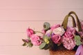 Bouquet of pink roses in basket on pink wooden background closeup. Roses and eustoma flowers greeting card, floristics Royalty Free Stock Photo