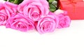 Bouquet of pink roses next to a red gift box isolated on white background Royalty Free Stock Photo