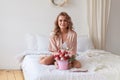 A bouquet of pink roses, strawberries and chocolate in the hands of the woman on the bed. Romantic gift in bed Royalty Free Stock Photo