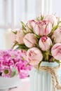 Bouquet of pink roses in turquoise ceramic vase