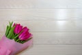 Bouquet of 5 pink tulips close-up on a light wooden background. The concept of holidays, events and gifts. Macro, place for text. Royalty Free Stock Photo