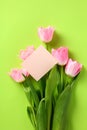 Bouquet of pink tulips and greeting card template on green background. Happy Mothers Day, International Womens Day, Birthday Royalty Free Stock Photo