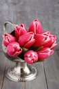 Bouquet of pink tulips in metal vase on wooden background Royalty Free Stock Photo