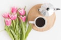 Bouquet of pink tulips, mug and moka pot on a white table Royalty Free Stock Photo