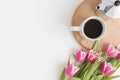 Bouquet of pink tulips, mug and moka pot on a white table. Flat lay with blank copy space Royalty Free Stock Photo