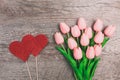 Bouquet of pink tulips and red two hearts from paper, on wooden background Royalty Free Stock Photo