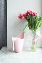 Bouquet of pink tulips and watering pot at home, indoor. Beautiful flowers, lifestyle. Holiday congratulation Royalty Free Stock Photo