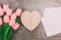 Bouquet of pink tulips and white blank envelopes, on wooden background Royalty Free Stock Photo