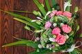 Bouquet of pink white green flowers arranged on wooden background. Roses, sedum, hosta, seed pods and grasses