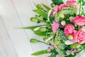 Bouquet of pink white green flowers arranged on wooden background. Roses, sedum, hosta, seed pods and grasses