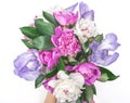 Bouquet of pink and white peonies and irises in woman`s hand isolated on white background. Flat lay.