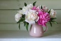 A bouquet of pink and white peonies on the table in a rural house Royalty Free Stock Photo