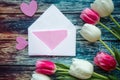 Bouquet of pink and white tulips and mockup blank on wooden background. Easter or Mother`s Day greeting card. Royalty Free Stock Photo