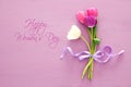 bouquet of pink and white tulips over pastel wooden background. Top view. International women day concept.