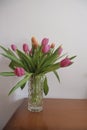 bouquet of pink and yellow tulips in vase closeup across white all on the wooden drawer. Interior detail. Hotel interior Royalty Free Stock Photo