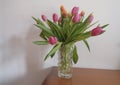 bouquet of pink and yellow tulips in vase closeup across white all on the wooden drawer. Interior detail. Hotel interior Royalty Free Stock Photo