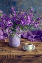 The bouquet of plant Matthiola farinosa and cup of coffee close-up