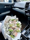 Bouquet of pretty white and pink flowers on the car seat Royalty Free Stock Photo