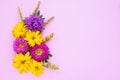 Bouquet of purple asters and yellow daisies on a pink paper background, mockup with copy space for text. Festive template, floral Royalty Free Stock Photo