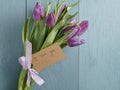 Bouquet of purple tulips tied with ribbon on blue wood table with paper card i love you Royalty Free Stock Photo