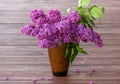 Bouquet purple Violet Lilac Flower  in a brown vase a wooden surface. Syringa vulgaris common lilac. Spring flowers Royalty Free Stock Photo