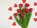 Bouquet of red blooming tulips with green stems and leaves and red paper heart Royalty Free Stock Photo