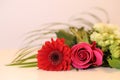 Bouquet of Red, Pink and White Flowers with Some Green on a Neutral Colored Table Royalty Free Stock Photo