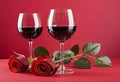 A bouquet of red roses on a red background with an empty wine glass placed in the center Royalty Free Stock Photo