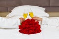 bouquet of red roses on the bed in a hotel room for honeymoon. romantic meeting of guests at the hotel. Royalty Free Stock Photo