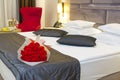 bouquet of red roses on the bed in a hotel room for honeymoon. romantic meeting of guests at the hotel. Royalty Free Stock Photo