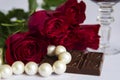 Bouquet of red roses, chocolate, glass of red wine, pearl