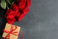 Bouquet of red roses and craft box with satin red ribbon Royalty Free Stock Photo