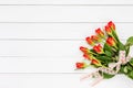 Bouquet of red roses decorated with lace on white wooden background Royalty Free Stock Photo