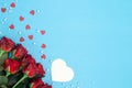 Bouquet of red roses and decorative hearts on a blue background, flat lay. Royalty Free Stock Photo