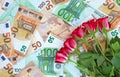 Bouquet of red roses on euro banknotes background. Financial, bank, money, economy, business concept.