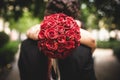 Bouquet of red roses held by a woman while hugging her lover Royalty Free Stock Photo