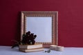 A bouquet of red roses lies on books, candles are burning, an old photo frame on a red background Royalty Free Stock Photo