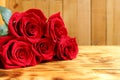 Bouquet of red roses lies on a wooden background