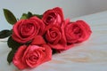 A bouquet of red roses lies on a wooden surface. Royalty Free Stock Photo