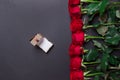 Bouquet of red roses and opened brown gift box on black background, with copy space Royalty Free Stock Photo