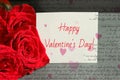 Bouquet of red roses and a sheet of white paper with a congratulation on Valentine`s day, Royalty Free Stock Photo