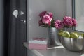 Bouquet of red roses, a steel bowl with green apples and a pink box with the inscription Best wishes on a stone windowsill. Room Royalty Free Stock Photo